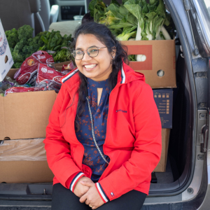 Acting Housing Coordinator Nikila Prodduk sitting on the back of a car